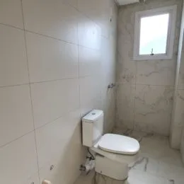 Foto de um banheiro com paredes brancas e um vaso sanitário.