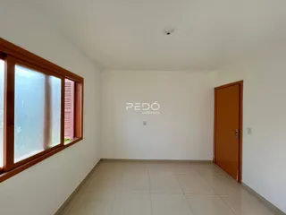Ambiente interno de uma sala com piso de cerâmica e porta de madeira.
