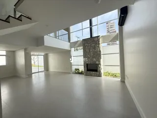Vista ampla de uma sala de estar moderna com grandes janelas.