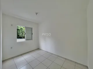Sala de estar com piso de cerâmica e paredes brancas.