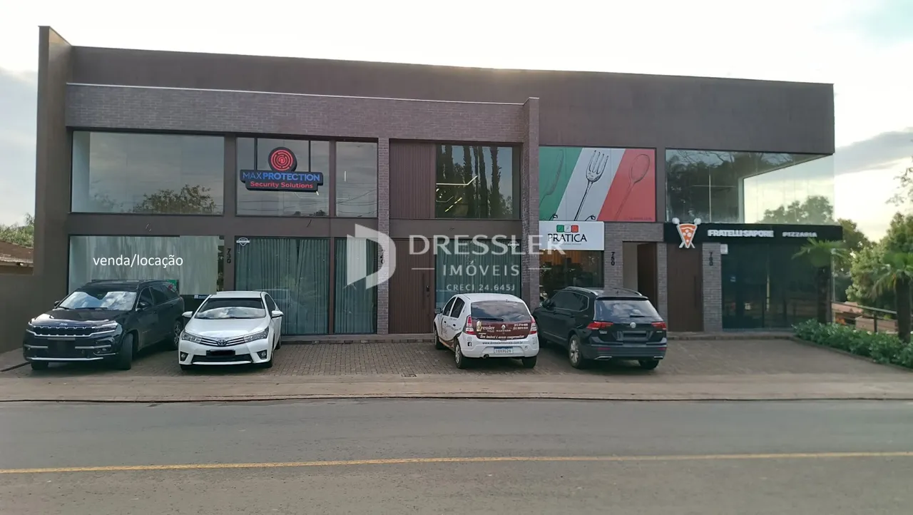 Fachada moderna de um imóvel em Lajeado, Brasil, com veículos estacionados na frente.
