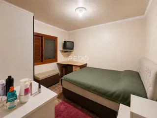 Foto do interior de um quarto com cama e móveis de madeira.