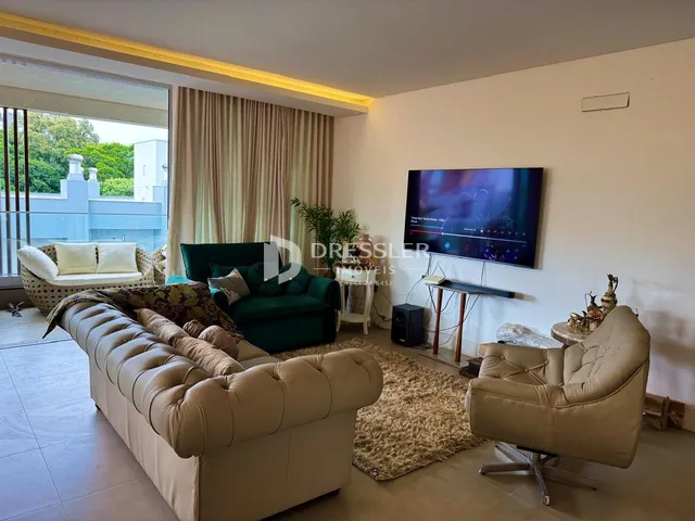 Sala de estar com sofá e televisão em um apartamento no Brasil.
