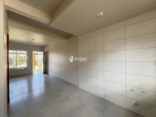 Hall de entrada com piso de cerâmica e paredes claras.