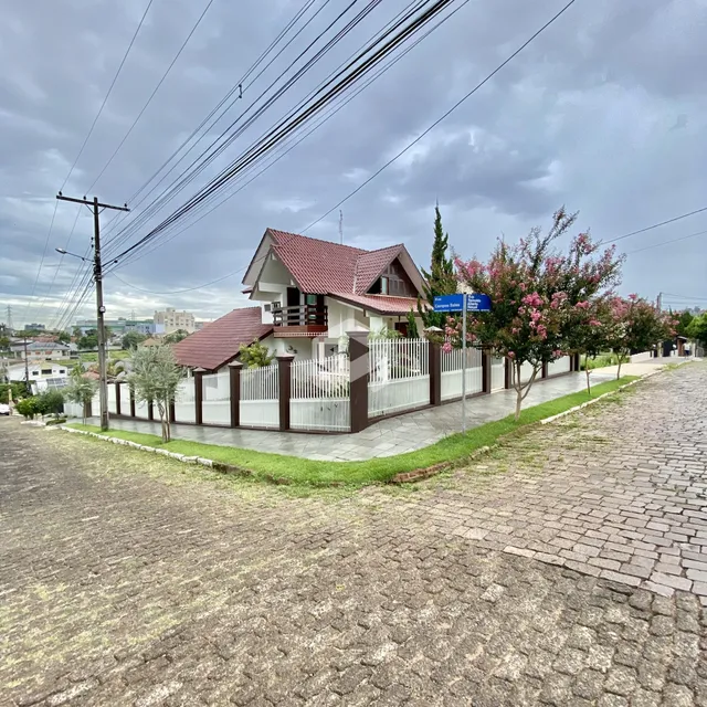 Fachada de uma casa residencial em Lajeado, Brasil, com cerca e paisagismo.