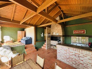 Sala de estar com teto de madeira e lareira em casa no Brasil.