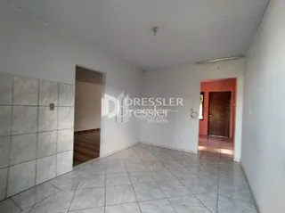 Vista interna de um ambiente com piso de cerâmica e paredes brancas.