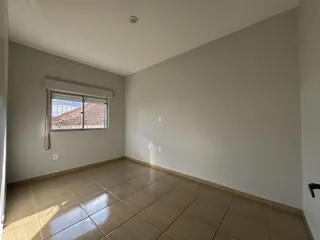 Quarto interno com piso de cerâmica e janela.
