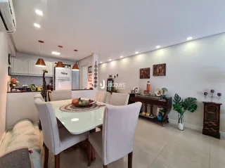 Ambiente interno de uma sala com mesa de jantar e estantes brancas.