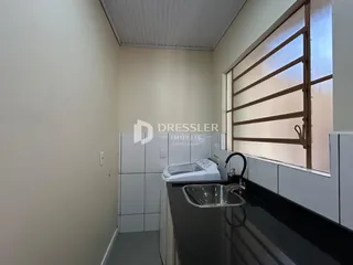 Foto de um banheiro com bancada escura e azulejos brancos.
