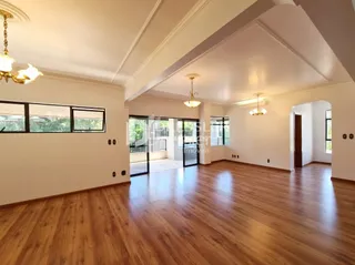 Sala de estar com piso de madeira e portas de vidro.