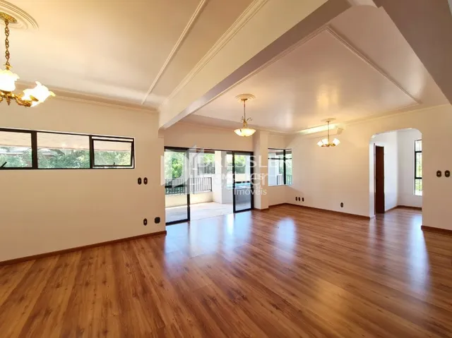 Sala de estar com piso de madeira e portas de vidro.