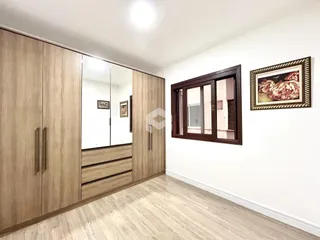 Quarto com armários em madeira e piso claro.