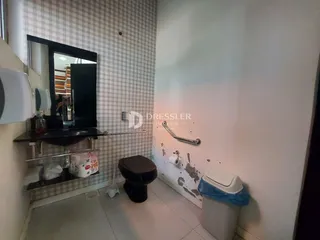 Foto de um banheiro interno com azulejos brancos e piso claro.