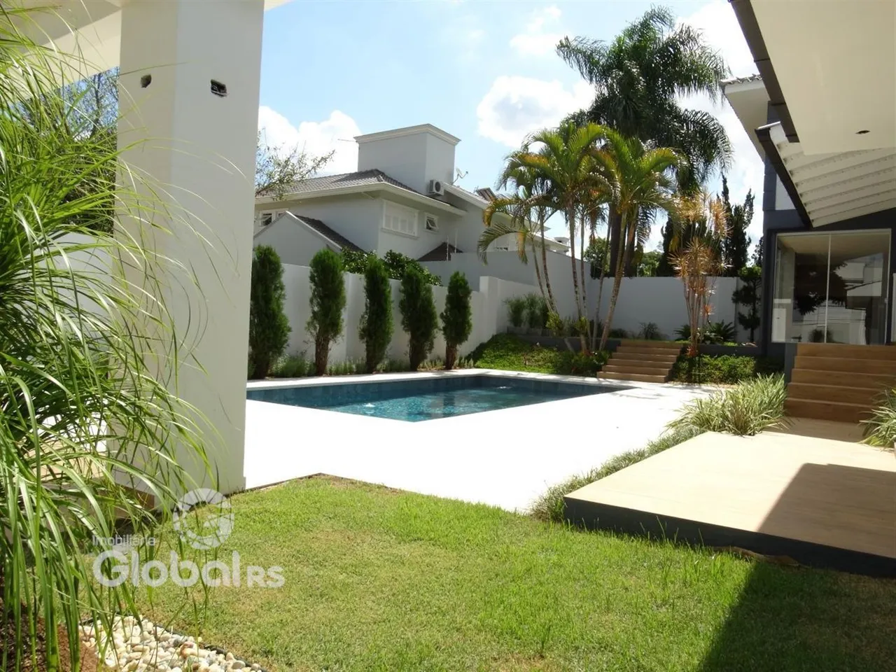 Foto da área da piscina e jardim de uma residência em Lajeado.