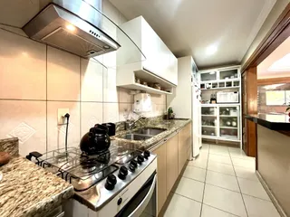 Cozinha com armários brancos e bancadas de granito.