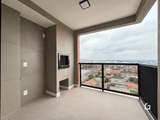 Vista de um ambiente interno com acesso a uma varanda com vista para a paisagem urbana.