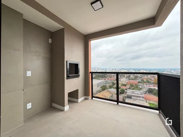 Vista de um ambiente interno com acesso a uma varanda com vista para a paisagem urbana.