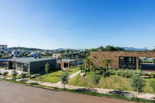 Vista externa de uma residência moderna com paisagismo em Lajeado, Brasil.