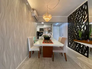 Uma sala de jantar com mesa e cadeiras brancas em um imóvel.