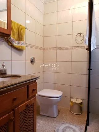 Foto de um banheiro com revestimento de cerâmica e vaso sanitário.