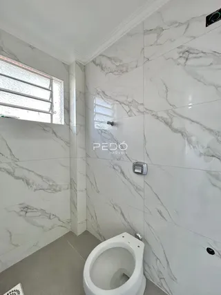 Foto de um banheiro com paredes em mármore branco.