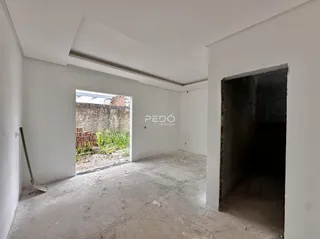 Ambiente interno de uma propriedade com piso de concreto aparente e paredes brancas.