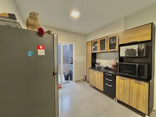 Interior de uma cozinha moderna com armários de madeira e eletrodomésticos.