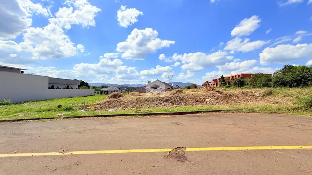 Vista externa de uma propriedade com área de terreno e vegetação seca.
