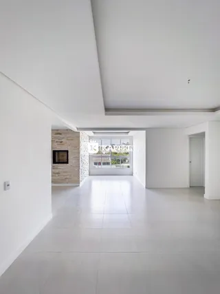 Hall de entrada com piso claro e parede de pedra no interior da residência.