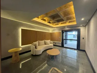 Sala de estar com piso de mármore e teto em caixão.
