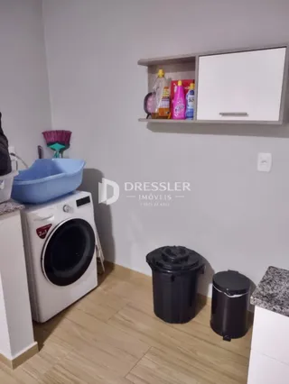 Foto de uma área interna com máquina de lavar e itens de utilidade.
