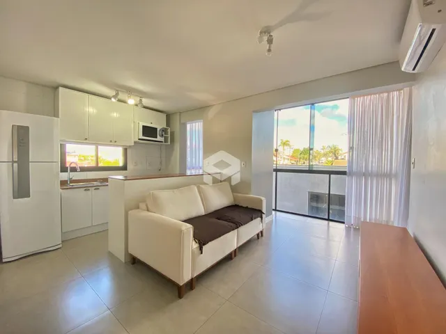 Sala de estar moderna com cozinha integrada e vista para o exterior.