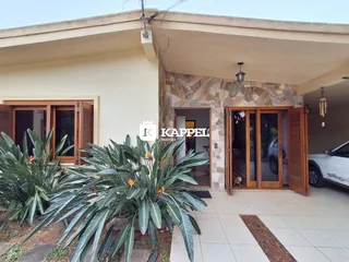 Fachada de uma residência em Lajeado, Brasil, com área externa coberta e vegetação.
