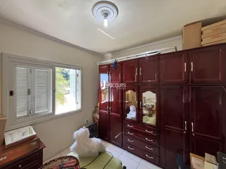 Quarto com armários em madeira escura e janela.