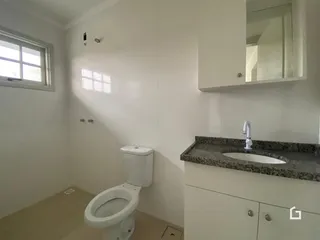 Foto de um banheiro moderno com piso claro e armário branco.