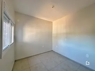 Vista interna de um cômodo com paredes claras e piso de cerâmica.