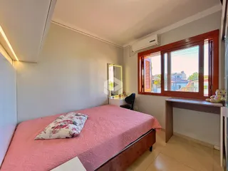 Quarto com cama e janela de madeira no imóvel.
