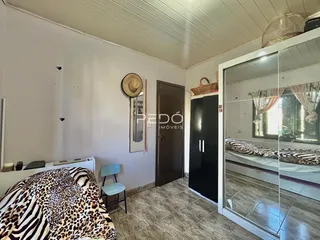 Quarto com cama de pele e porta de madeira em um imóvel no Brasil.