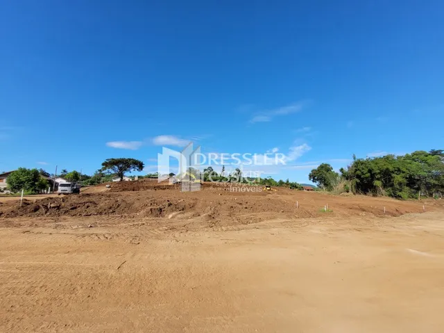 Terreno de terra seca sob um céu azul.