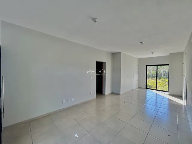 Ambiente interno de uma sala com piso de cerâmica e paredes brancas.