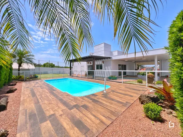 Foto de uma piscina e deck de madeira em uma propriedade.