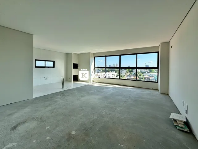 Ambiente interno amplo com piso de concreto e grande janela de vista urbana.