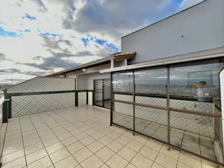 Vista da área externa com piso de cerâmica e grade de segurança de uma residência.
