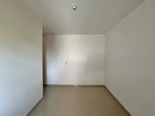 Hall de entrada de um imóvel com paredes brancas e piso claro.
