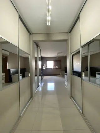 Um corredor interno com paredes espelhadas e piso claro.
