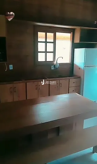 Vista interna de uma sala com móveis de madeira e janela.