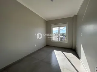 Vista interna de um ambiente com piso de cerâmica e janela.