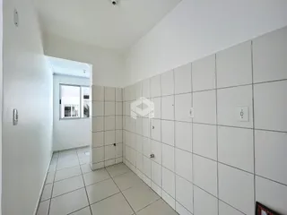 Hall de entrada com piso de cerâmica clara nas paredes brancas.