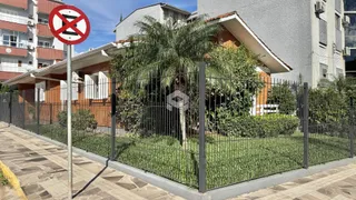 Vista da fachada de uma residência com cerca e vegetação no Brasil.